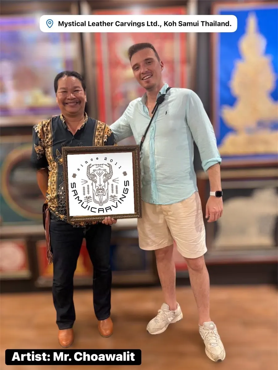 The artist with a guest, holding a framed leather carving in his gallery