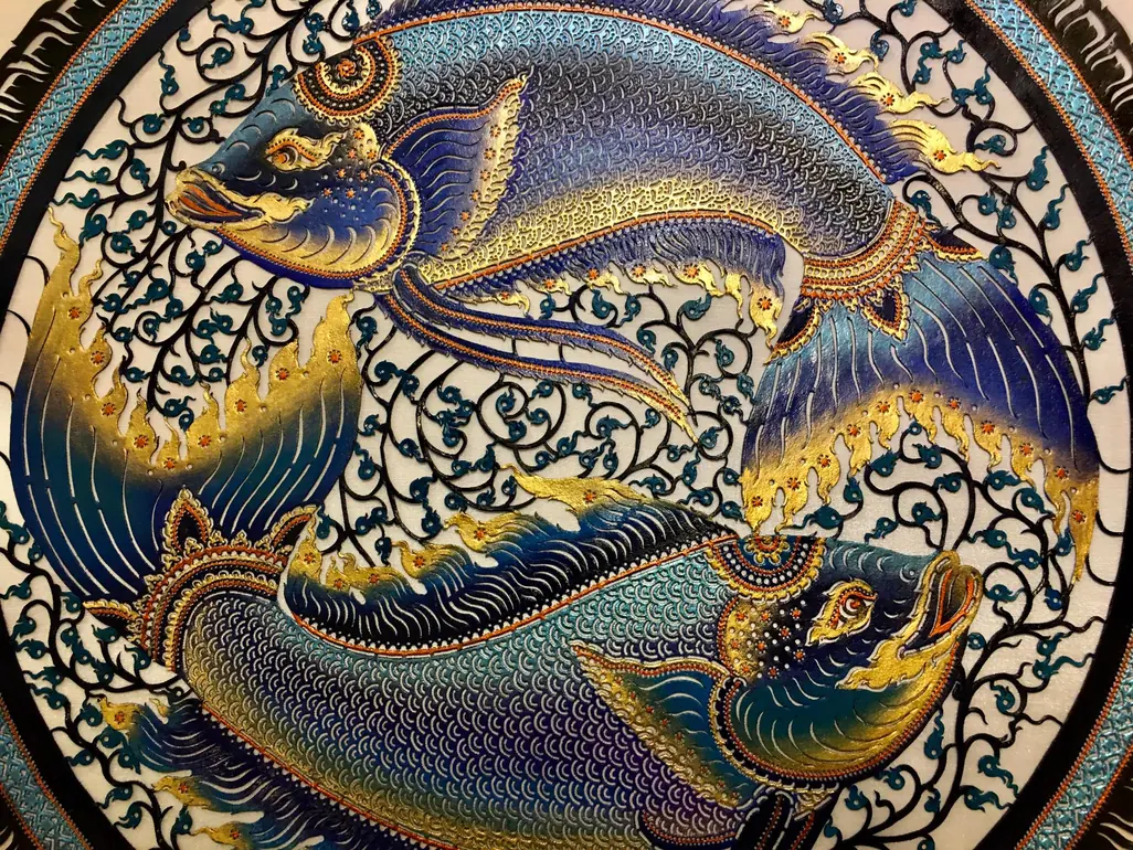 The fish medallion: two painted fish in a ring of cut leather lace