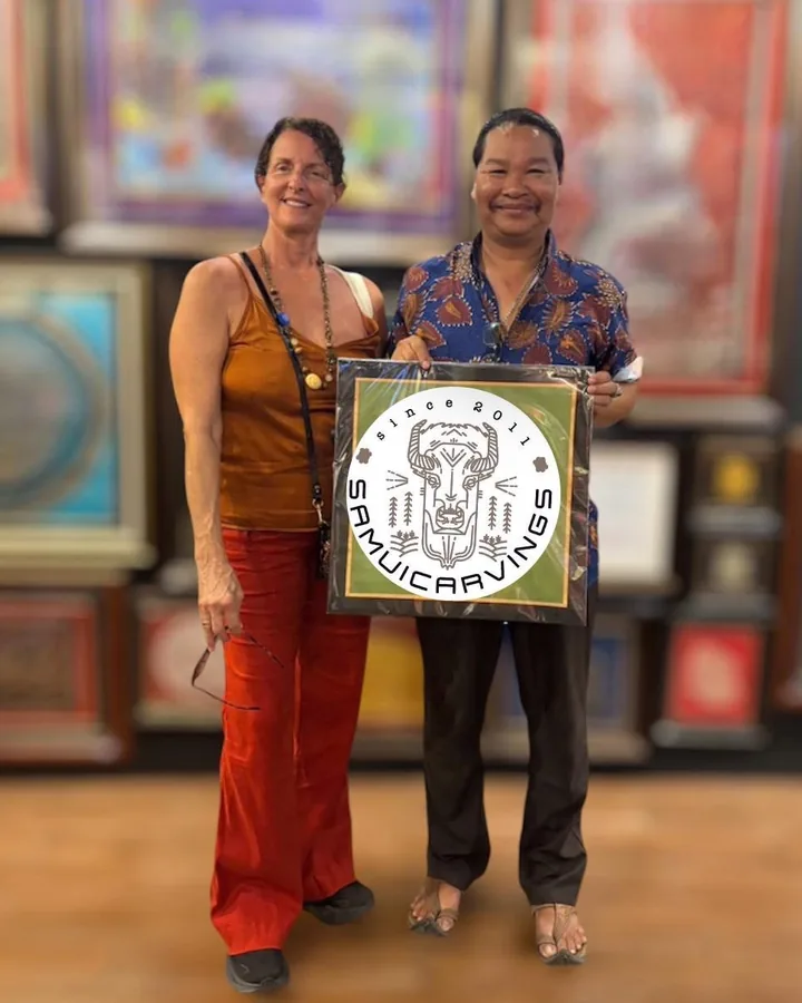 Mr. Choawalit and a guest holding a framed Samui Carvings print